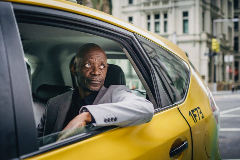 black man in elegant coat in taxi